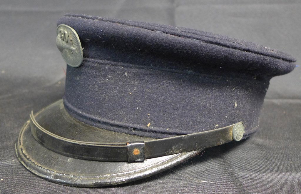 Vintage US Fire Department Dress Hat: Navy blue wool flat top hat with black rim. Side buttons read: FD. Center cap badge has image of a trumpet and the numbers 304. Maker's label found in inside of hat: Helmet brand Reg. US Pat Off., #29