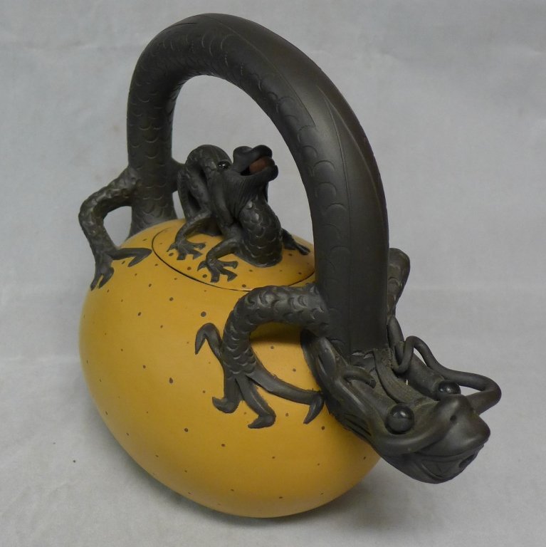 Unique Asian Art Pottery Figural Teapot: Beautifully sculpted Asian egg shaped ceramic teapot with dragon as handle and finial on lid. Painted in lovely yellow and brown earth tone colors. Stamp on tail reads: CCC1 2004. Maker's mark/ seal m