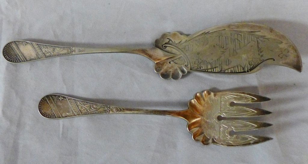 Reed & Barton Fish Serving Knife and Fork: Antique silver plate serving knife and fork set. Beautifully engraved pond scene with fish, cattails, and dragonfly. Both handles have stylized floral patterns. Stems are marked "Reed & Barton". Lengt