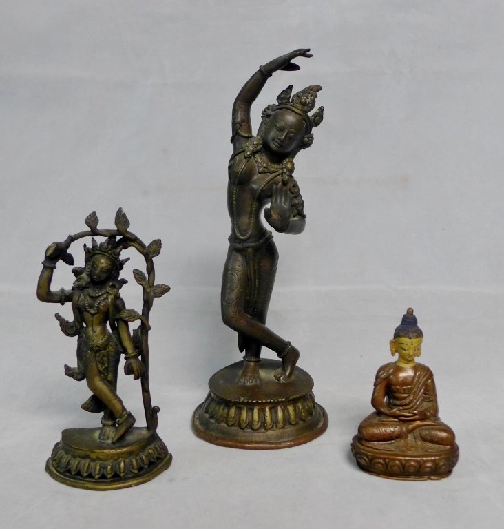 Asian Bronze Grouping: Collection of Asian deities include: a seated Buddha with painted face and two standing goddesses (both possibly Parvati). Bronze figure with tree branch has noticeable damage at hand and tree connect