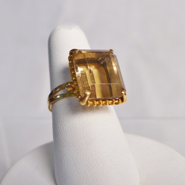 Large Citrine Solitaire Ring: Large Citrine Solitaire Ring. Large (possible/untested) citrine stone is set in yellow gold with a split band. Makers mark on band. Total approximate weight: 5 grams. Ring size: 7. STERLING ASSOCIATES