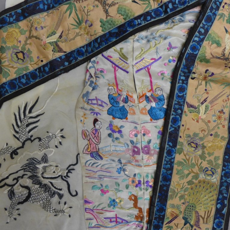 Grouping of Asian Embroidery: Examples of beautiful and ornate embroidery work. Sheer scarf depicts a dragon. The two panels stitched together show mirror images of an outdoor figural scene. Height: 18", Width: 7" The other two pi