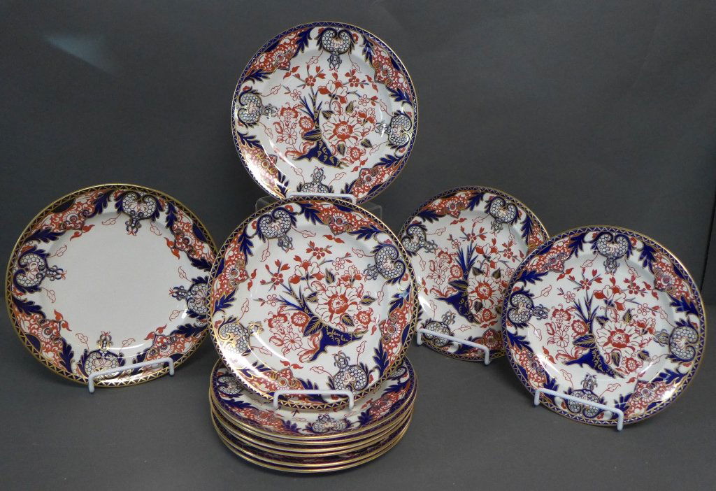 Royal Crown Derby Japan Pattern Plates: Eleven Imari English porcelain plates with gold embellished Kings Pattern. Maker's mark on back. Two different plates, set of ten (noticeable chip on one) and one slightly larger plate. Diameter: 8" &