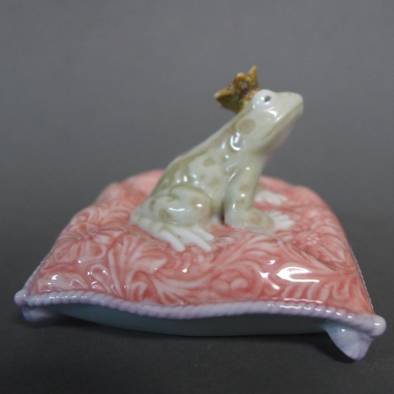 Lladro Frog Prince Porcelain Figurine: "Enchanted Prince" designed by Jose Javier Malavia and issued in 2009. Frog with crown seated on pillow. Maker's mark on bottom. Height: 2", Width: 2 3/4", Depth: 3"(toad, sculpture, statue, collectib