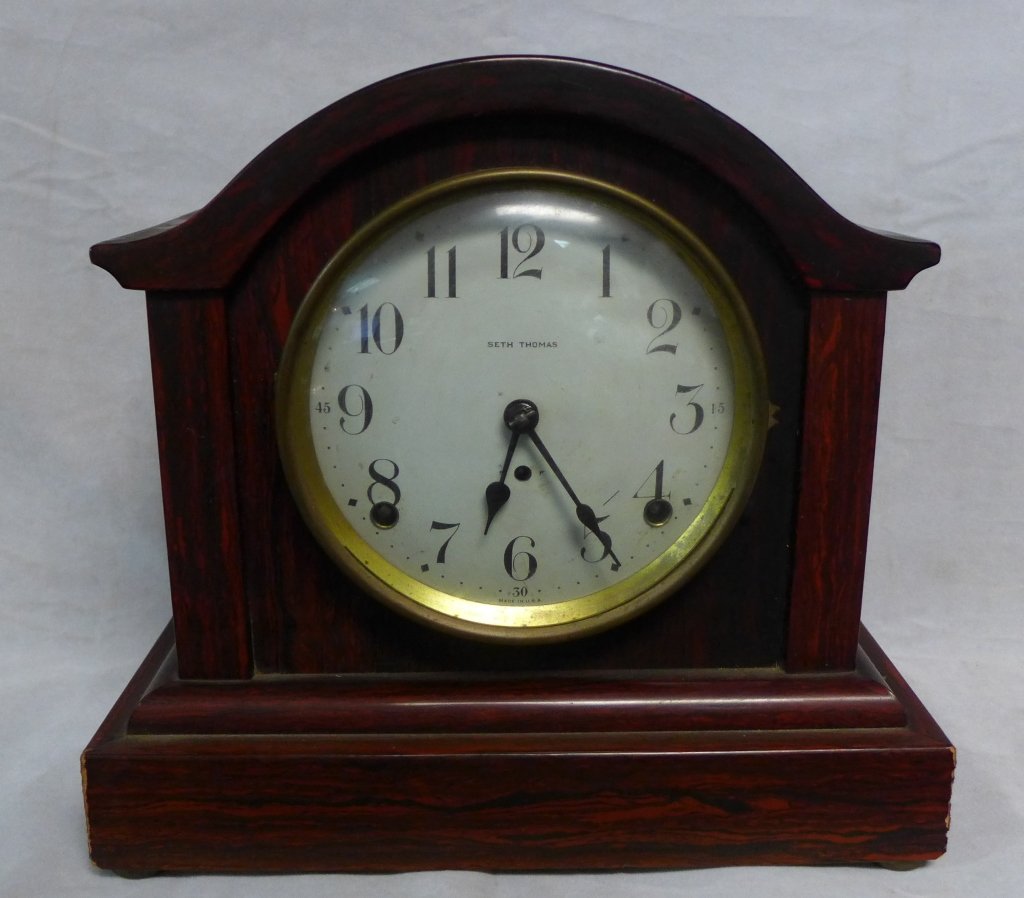 Seth Thomas Mantle Clock: Antique veneer clock with rosewood finish. With pendulum. Some slight imperfections. Height: 9 1/2", Width: 10", Depth: 5 3/4"(time, shelf clock, decorative accessory, collectible)STERLING ASSOCIATES