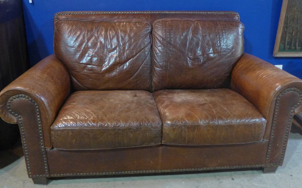 Leather Club Sofa Couch: Beautiful English brown leather couch with deep seating. Stunning textured brown leather. With large decorative nail head accents. Cushions are not removable. No noticeable maker's label. Some slight