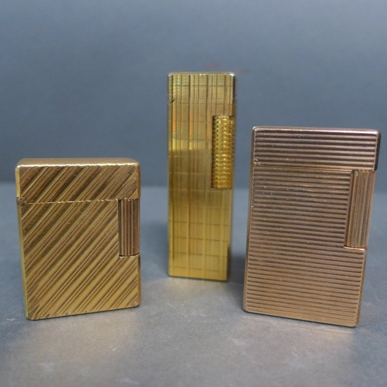 Vintage DuPont and Colibri Lighter: Collection includes: -Gold tone horizontal line surface with vertical roller. Roller does not turn. Bottom marked: ST. Dupont, Paris Made in France. 7774AC. Missing piece under lid. Height: 2 1/4" -Go