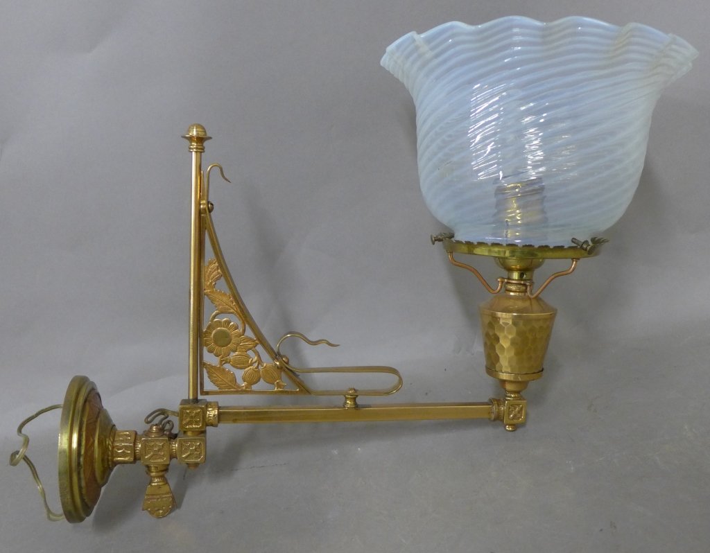 Victorian Aesthetic Sconce: Beautiful gas light brass/ bronze single sconce with floral design. Opaline glass shade with ruffle rim. Flat circular back plate unattached. Chip on bottom rim of glass. Height not including glass sh