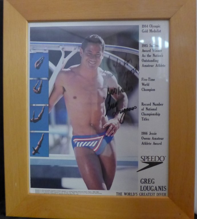 Greg Louganis Autographed Photo: Color photo of Greg Louganis. Inscribed and signed. Letter adhered to back. American Olympic diver, LGBT activist, and author who won gold medals at the 1984 and 1988 Olympic Games. Height: 13 3/4"; W
