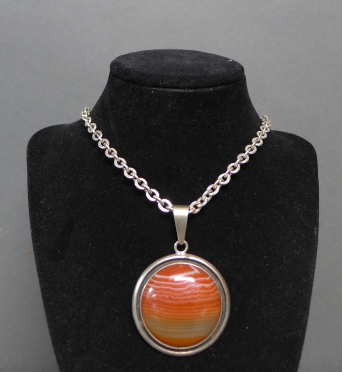 Charles Albert Sterling Silver Pendant & Necklace: Large circular striped agate cabochon bezel set in sterling silver. No clasp on necklace. Approximate total weight: 75 grams. Length of chain: 25", Height of pendant (w/ bail): 2 5/8", Diameter of pen