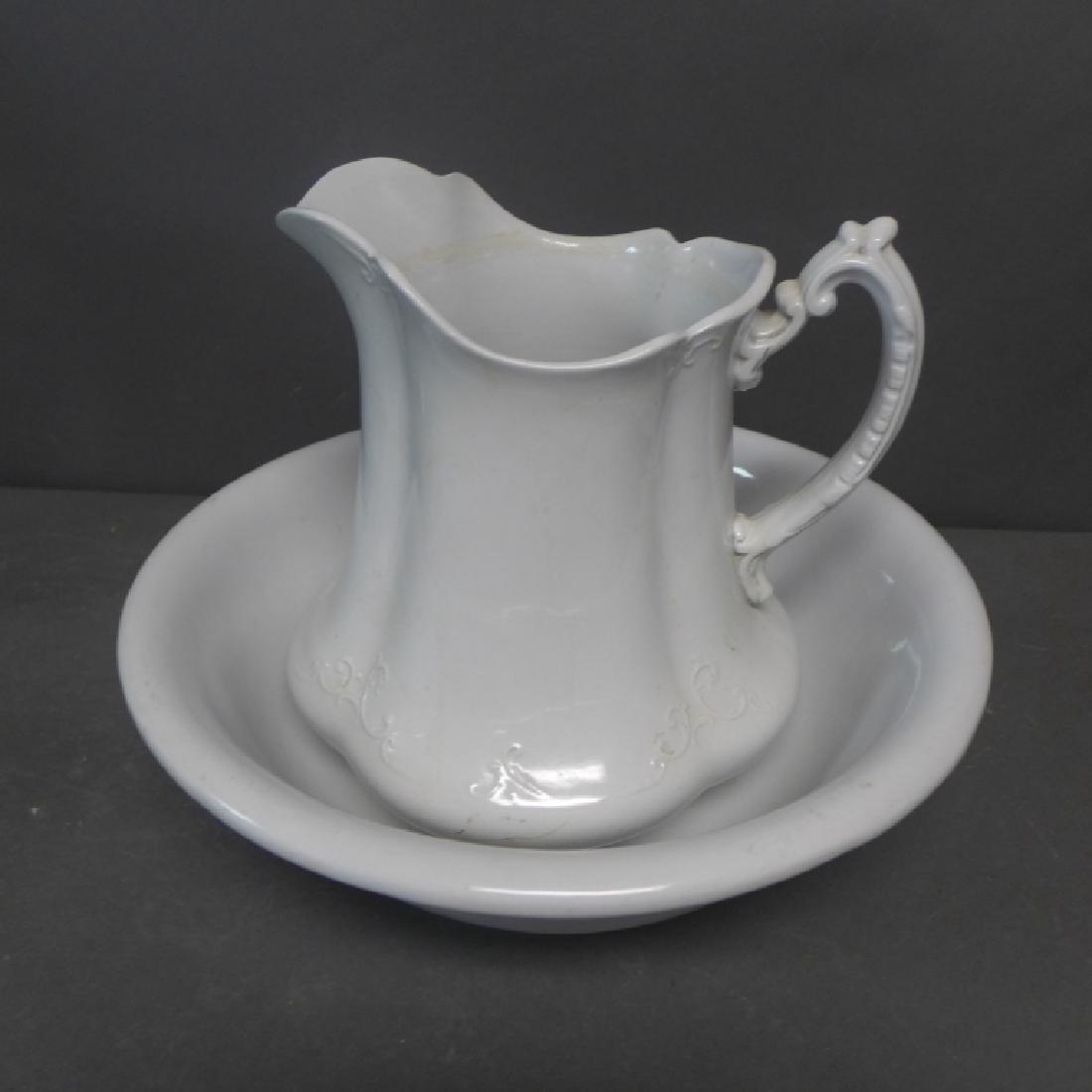 English Ironstone Pitcher And Basin: Beautiful vintage white glazed pitcher and basin. Maker's marks on bottom. No noticeable chips or cracks. Some imperfections and wear. Height of pitcher: 10" & Diameter of Basin: 13 1/2" (decorative a