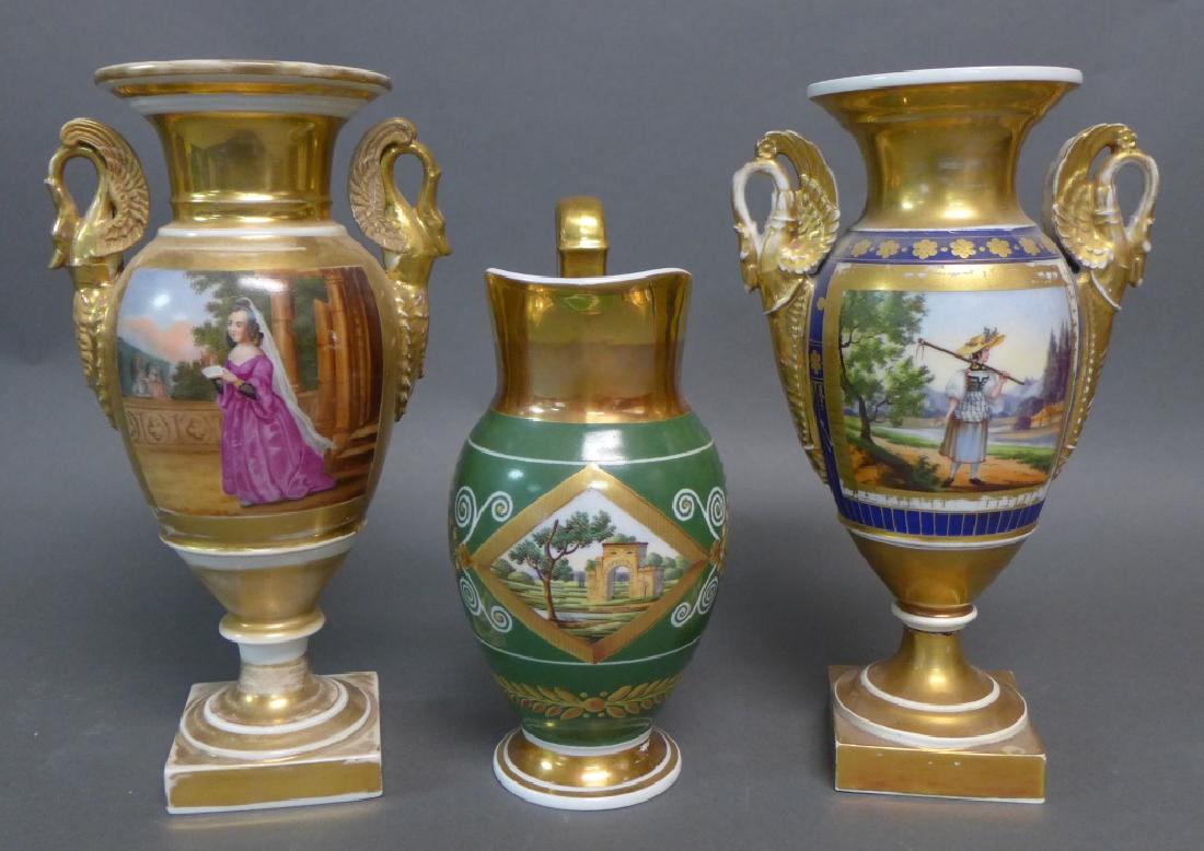Old Paris Neoclassical Vases and Pitcher: To stunning antique swan handled Old Paris vases/ urns along with elegant pitcher. 19th Century. Urns have sweetly painted panels depicting outdoor figural scenes. Pitcher has topography scene painted