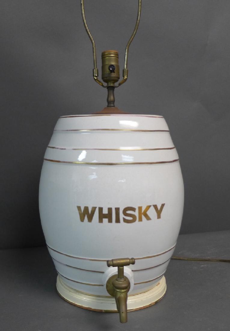 Whiskey Porcelain Barrel as Lamp: Whiskey porcelain barrel or cask with gilt banding. Brass spigot at bottom. Liquor barrel sits on round wood base. Spout is removable. Electrified as lamp. Height up to socket: 18", Width including sp