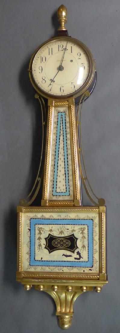 Waltham Banjo Clock: Waltham Clock Company of Waltham, Massachusetts. circa 1925. Stunning timepiece with reverse painted tablets and gilt wood frame. The brass bezel is fitted with convex glass and opens to a painted iro