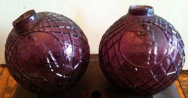 Two Early Glass Target Balls, Amethyst: Outstanding glass target balls with shooters embosses. Deep purple color. Condition: Good, slight chipping on lips.