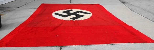 Nazi Germany Double Sided Building Drape / Flag: Nazi Germany double sided building drape/flag. Dimensions: 13.5' x 19.5' Condition: Fair condition, Grommets are intact, numerous small holes & tears noted. Provenance: Private collection