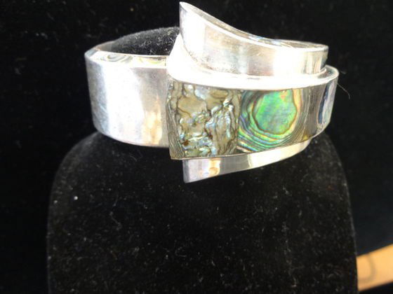 Taxco Sterling & Abalone Cuff Bracelet, c. 1940s: Taxco Sterling & Abalone Hinged Cuff Bracelet.Designer J. Gomez, c. 1940sMarked on interior.Weight: 75.8 gr.Dimensions: 8 1/4" (L) x 1" with flare to 1 3/4" at end.Condition: Excellent vintage conditi