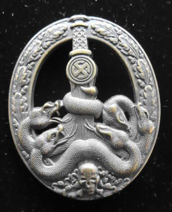 WW 2 German Nazi Anti-Partisan Badge, Gold: Anti-Partisan War Badge - Gold. Relief dull gold oak leaf decorated oval wreath, upper portion cut-out, "sun-wheel" swastika below hilt of broad sword - pointed downward between entangled serpents and