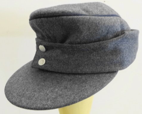 WW2 German Luftwaffe M43 Cap Marked: WW2 German Luftwaffe M43 Wool Lt Blue/Grey Cap, dark blue string trim with silver buttons. Marked on inside not all legible except for 1003 Berlin 44 Condition: Very Good -There are rips to leather in