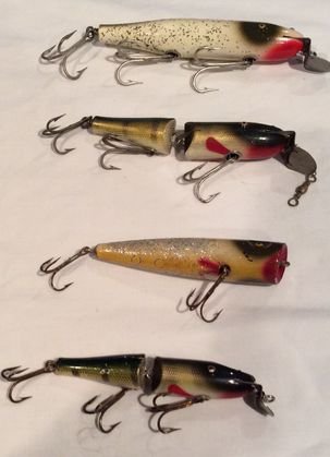 Antique Fishing Lures, Creek Chub Pixies, (4): Wood fishing lures with glass eyes, Two (2) jointed. Dimension: Largest: 6 1/2"; Smallest: 5" Condition: Good Provenance: New Jersey Estate