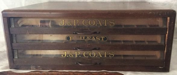 J & P Coats Spool Sewing Wood Cabinet: J & P Coats, 3 glass front drawers, wood box with advertising logo on front and sides. Dimension: 8-1/2"H x 17-1/2"D x 19-1/2"A Condition: Very good, minor scratching to wood, One (1) drawer worn lett