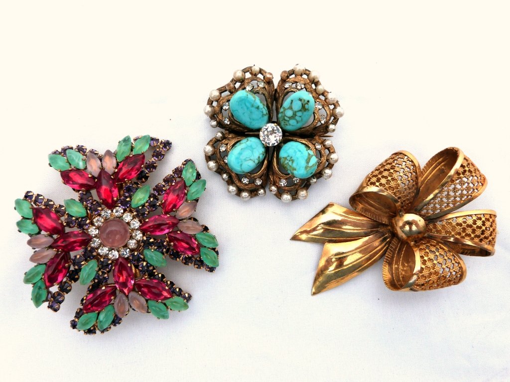 Chanel Pin & Two Bow Shaped Pins ,French: Three Bow Shaped Pins French, one beaded, one French gilt metal, and the other Chanel. the chanel pin is 2" D, the large multicolored pin is 2 1/2" D gold colored ribbon pin is 3" L 2"W all are in goo
