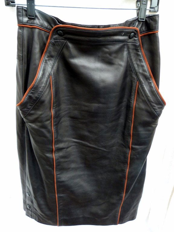 Two Escada Lambskin Leather Skirts: One with brown piping size 38, the other a black leather skirt with gold studs size 38. Superb quality. Good Condition
