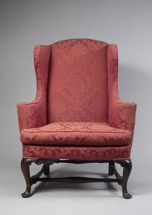 QUEEN ANNE UPHOLSTERED STAINED MAPLE EASY CHAIR: The wings continuing to conical arms, the balloon-shaped seat rail above cabriole legs flanked by shaped brackets, joined by swelled stretchers with arrow-shaped terminals.