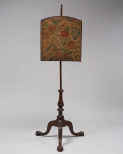 CHIPPENDALE MAHOGANY POLE-SCREEN, ca. 1760: The pole with integral acorn finial and what appears to be its original adjustable screen and original mid-18th century needlework panel depicting a basket of flowers, the shaft with spiral carved