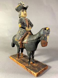 CARVED AND PAINTED PINE FIGURE OF A MAN ON HORSEBACK: American, probably New England, 18th century. The white pine figure and horse on a fitted rectangular section of wood which appears to be original to the sculpture. Provenance: Purchased circa