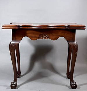 DIMINUTIVE CHIPPENDALE SHELL-CARVED MAHOGANY CARD TABLE: New York, circa 1765 . The highly figured fold-over mahogany top with serpentine-front and sides, opening to form a playing surface supported by the rectangular box-frame and a swing-leg, the lower