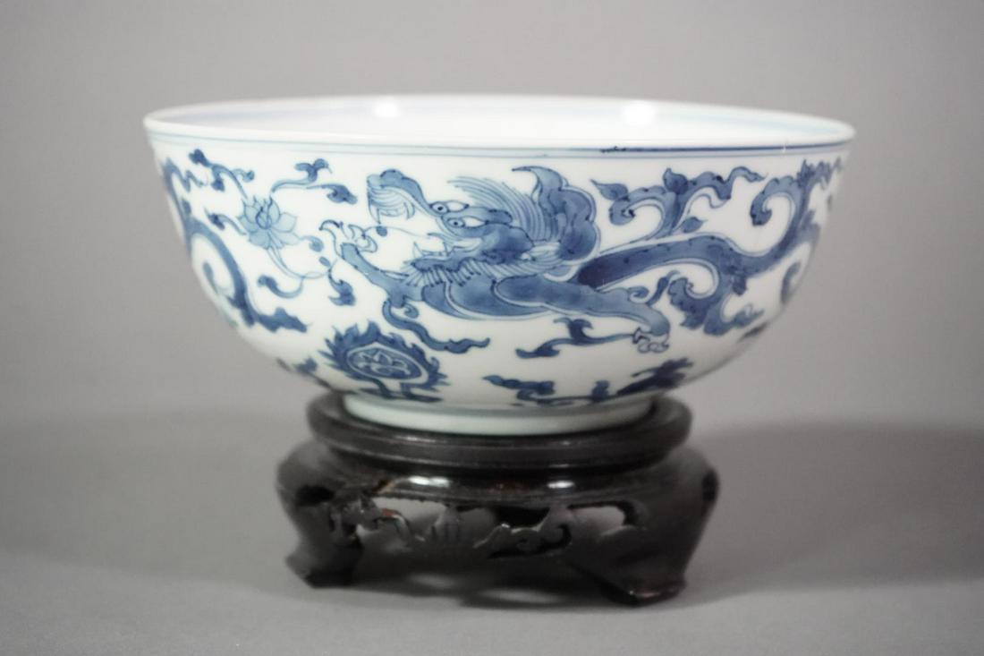 BLUE AND WHITE ‘KUI DRAGON’ PORCELAIN BOWL: Kangxi period (1661-1722) Blue and white 'kui dragon' porcelain bowl with apocryphal chenghua mark and of the kangxi period (1644-1722) With hardwood stand. The two striding dragons each in mutual pur