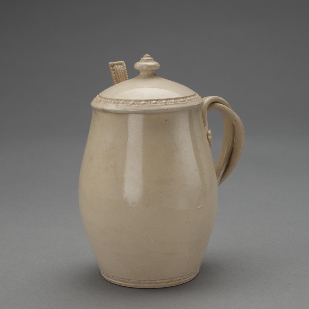 CREAMWARE CUP AND VINE-TWIST HANDLE WITH A SPOON: English, circa 1780. Ovoid body with beading at base and on lid; entwined handles with flowerhead terminals. Dimensions: Height of Covered Mustard Cup:4 inches Provenance: A Distinguished New York Col