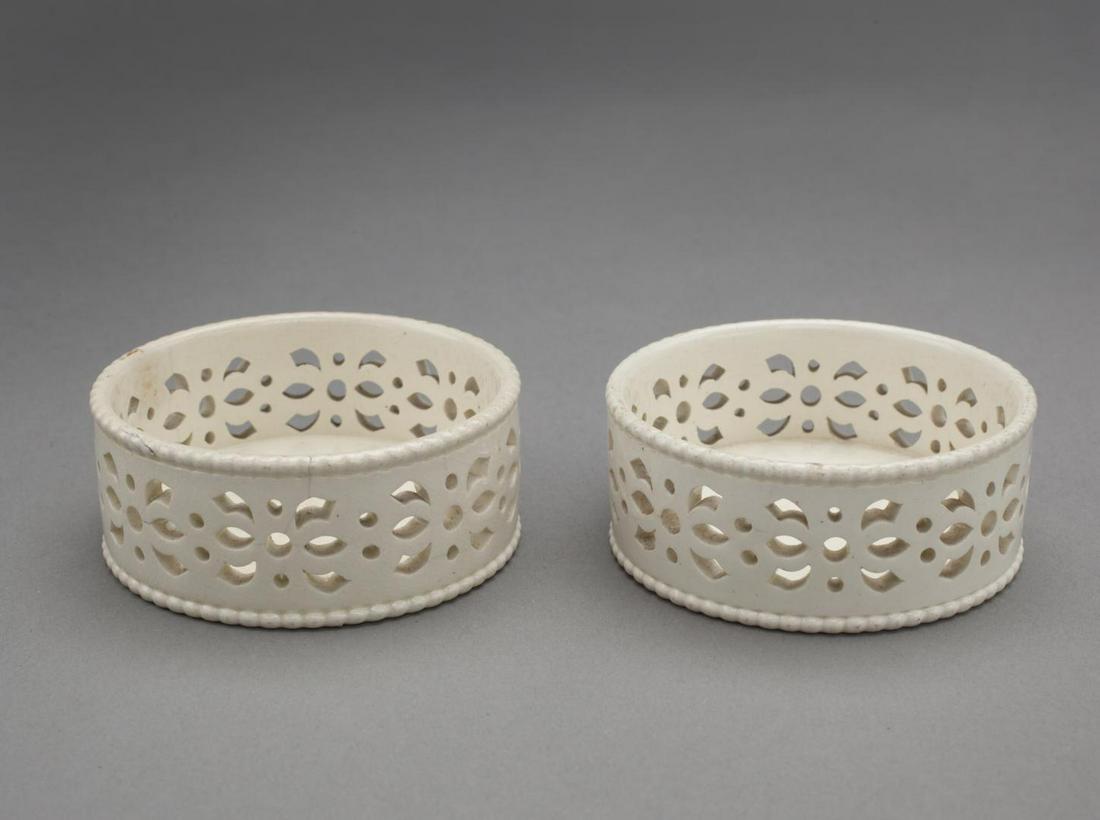 PAIR OF CYLINDRICAL “GLASS STANDS” W/ PIERCED SIDES: Wedgwood, circa 1775. A pair of coasters or kettle stands of cylindrical form the sides entirely pierced.Labels on underside print, "Glass Stand Leeds Cat No 187-Towner" "Leeds Pottery", Plate *4 Mark