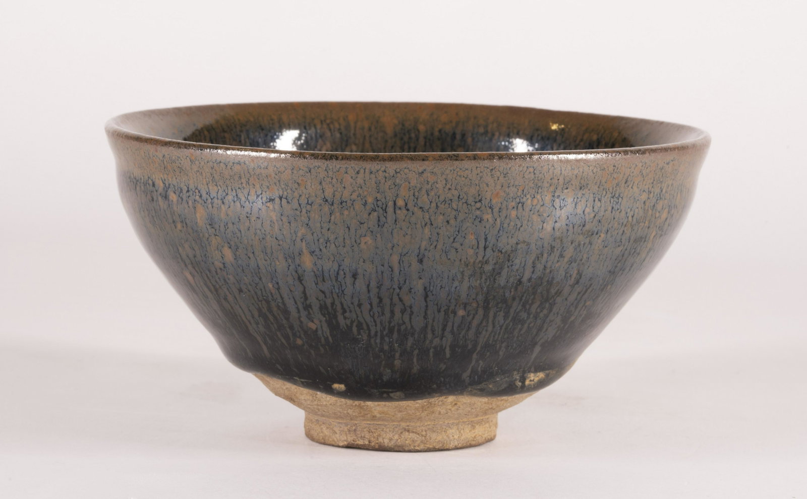 Jian 'Hare's Fur' Tenmoku Tea Bowl: Southern Song Dynasty (1127-1279) The bowl thinly potted with a narrow groove below the rim and with gently sloping sides, covered overall with an unctuous black glaze streaked with fine 'hare'