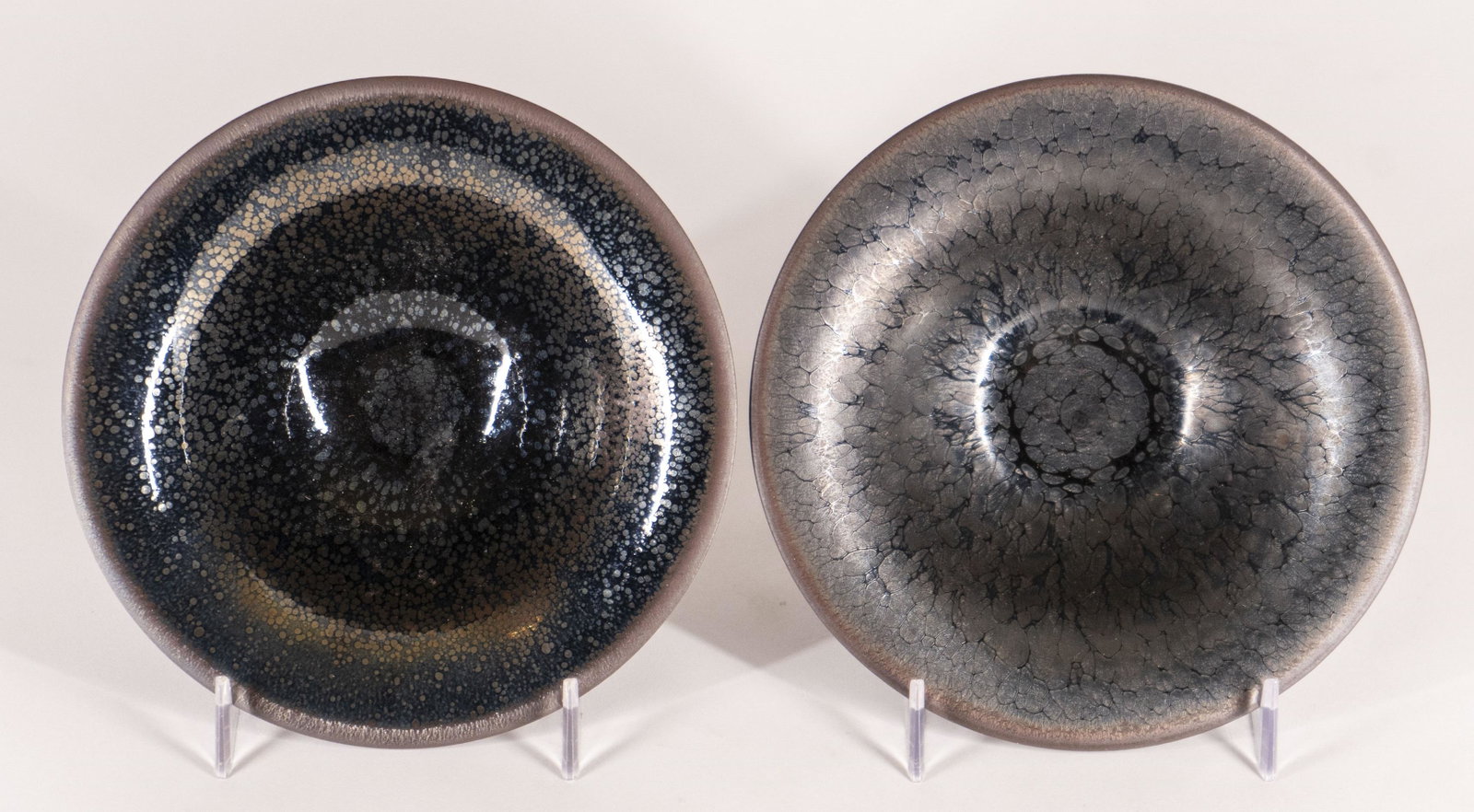 Pair of Jian Style Tea Bowls: 20th Century Each with everted rim and sloping sides with a thick 'oil spot' glaze stopping above the foot rim to reveal the buff colored stoneware body. Each, H. 2 1/4 in., D. 6 1/4 in. Condi