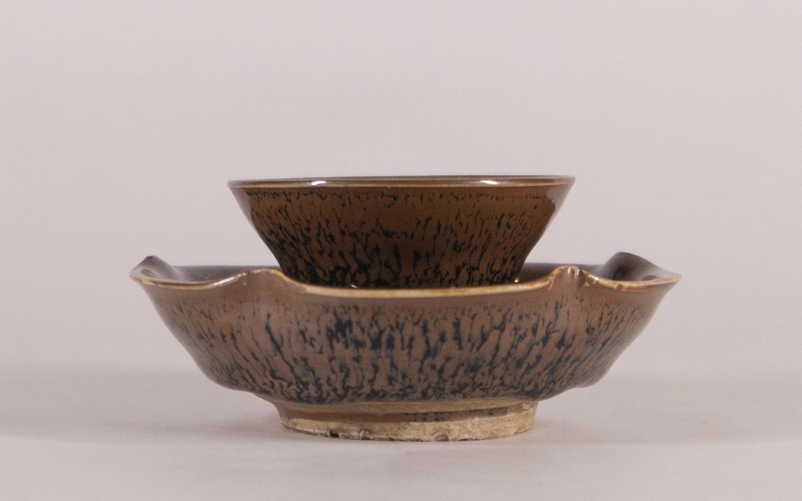 Jian "Hare's Fur" Tea Bowl and Stand: Southern Song Dynasty (1127-1279) Finely potted, covered overall with a rich glaze streaked with fine 'hare's fur' markings on both the exterior and interior, the thick glaze stopping abov