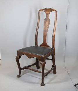 Queen Anne Walnut Side Chair: Boston, circa 1735 With shaped crest and vase form splat over black leather upholstered slip seat with scalloped skirt, cabriole legs set with turned roundels at knees, turned stretchers and pad feet,