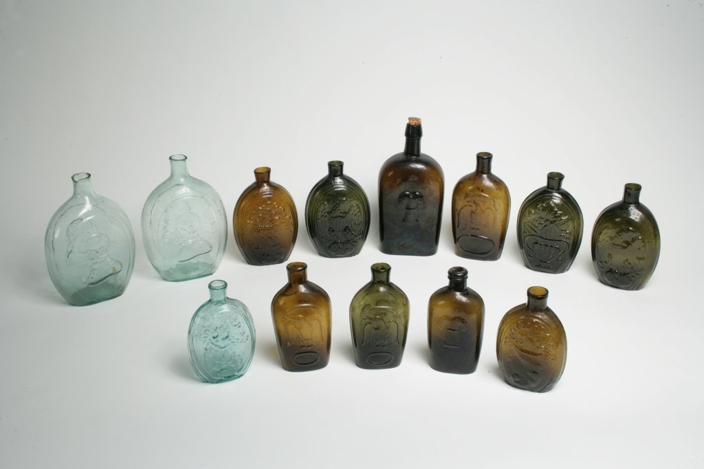 Group of Thirteen Flasks: American, first half, 19th Century Comprising: Dyotteville Glass Works, Philadelphia, Pennsylvania Aqua glass "The Father of Our Country" "GEN. TAYLOR NEVER SURRENDERS / DYOTTEVILLE GLASS WORKS,Ó Geo