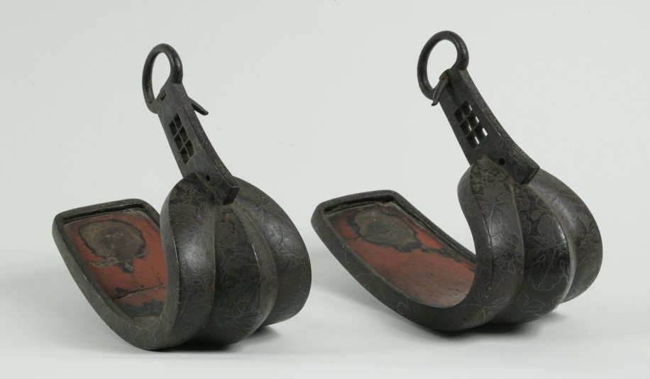 Pair of Silver-Inlaid Stirrups (Abumi): Edo Period, 18th century Each signed by the Japanese artist who created each Stirrup With red lacquer coated interiors. H. 10 _ in. Estimate: $500 - $1,000 Condition: Wear, mostly to Lacquer in interi
