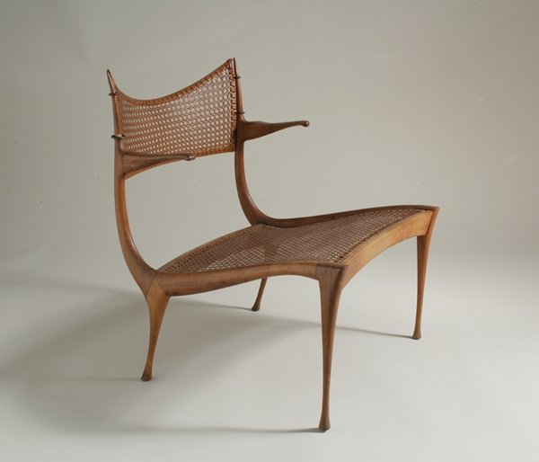 Dan Johnson, Gazelle Lounge Chair, Model no. 30W: From a Private New York Collection *Dan Johnson (American, b. 1938) Gazelle Lounge Chair, Model no. 30W Dan Johnson Studio USA, c. 1957 Italian walnut, cane and brass H. 28 in.; W. 23 1⁄4 in.; D