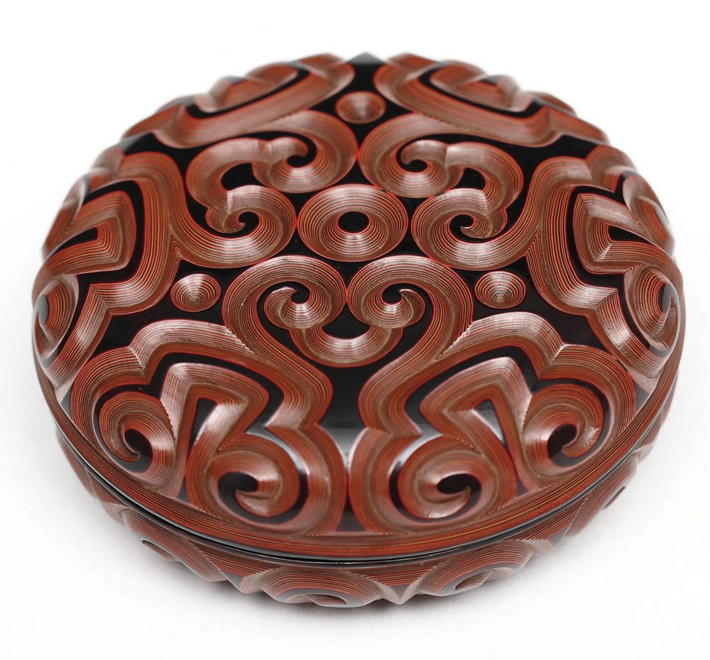 Ming Dynasty, 16th Century-A Tixi Cinnabar Lacquer: The upper surface and sides of the cover deeply carved through alternating layers of black, red and yellow lacquer with ruyi scrolls. W: 2-1/2 in. 明 剔犀層雕 如