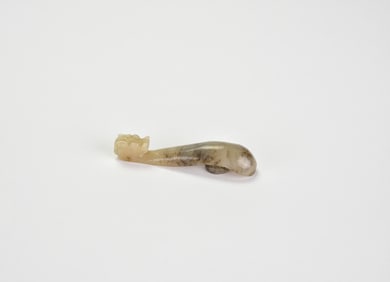 A Celadon and Russet Jade Belt Hook, Qing Dynasty or Later.