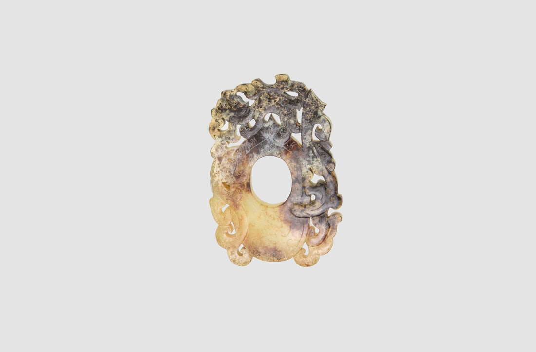 A Rare Archaizing Celadon And Russet Jade Openwork Pendant With Chi-Dragonshan Dynasty (206 Bce –: A Rare Archaizing Celadon And Russet Jade Openwork Pendant With Chi-Dragonshan Dynasty (206 Bce – 220 Ce)Carved in openwork with an oval aperture encircled by four chi dragons in high relief, th