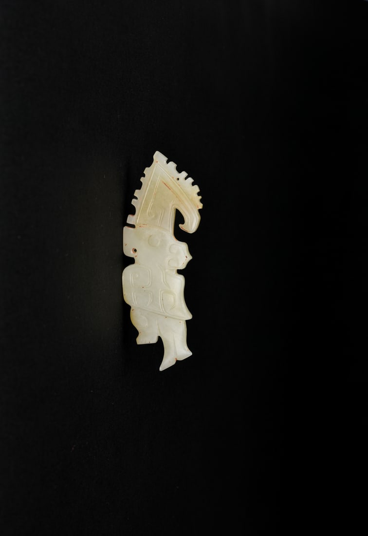 A Celadon Jade Dragon-shaped Pendant, Shang to Western Zhou Dynasty (circa 13th–9th Century BC): A Celadon Jade Dragon-shaped Pendant, Shang to Western Zhou Dynasty (circa 13th–9th Century BC)Finely carved in a stylized silhouette, the pendant shows a dragon with a backward-curving head and
