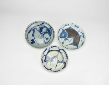 A Group of Three Blue and White and Underglaze Copper-Red ‘Fish’ Dishes, Late Ming to Early Qing