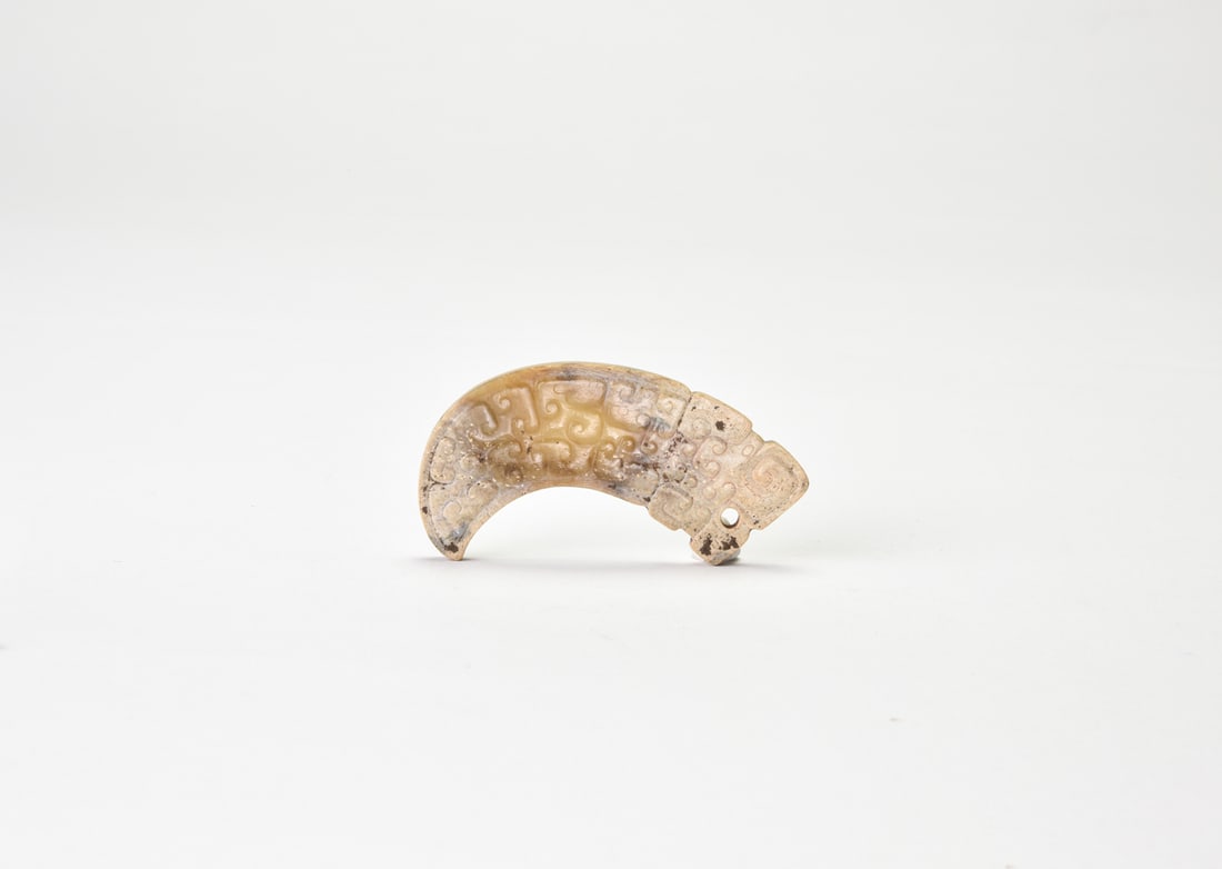 Han Dynasty. Arched Jade Pendant with Cloud-and-Dragon Motif.: The jade is of warm grayish-white to light buff tone, with areas of natural surface alteration and calcification. Carved in an arched pendant form and pierced at one end for suspension, the profile is