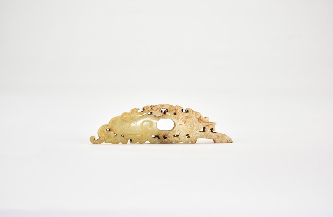 Late Warring States Period (circa 4th–3rd century BC). A Carved Jade ‘Chilong’ Pendant.: The pendant is carved from a single piece of jade, elongated and flattened in form, with gently undulating surfaces. Both sides are decorated in shallow relief with chilong dragons interwoven with scr