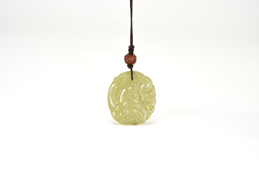 Late Qing to Early Republic Period. A Celadon Jade ‘Ruyi’ Cloud Pendant. (1 of 6)
