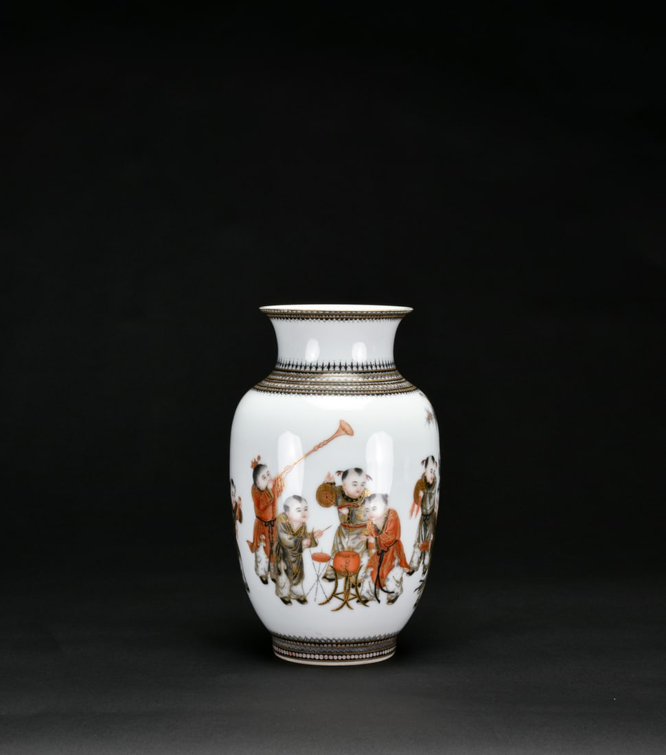 Qing A Famille Rose and Gilt ?Boys? Vase, Iron-Red ?Qianlong? Mark: The vase of baluster form with a flared neck is finely painted in famille rose enamels with a lively scene of boys at play, accompanied by auspicious objects, the reverse inscribed with a poetic text.